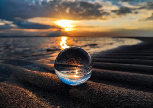 Image of horizon taken from the ground, with a sphere in the foreground, to show the contrast between the idea the earth is flat and the earth is round, used as an explainer to show how we seek confirmation bias